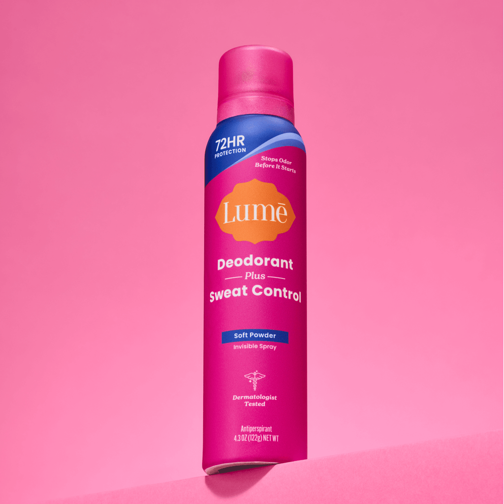 A can of Lume spray deodorant plus sweat control in front of a pink backdrop.