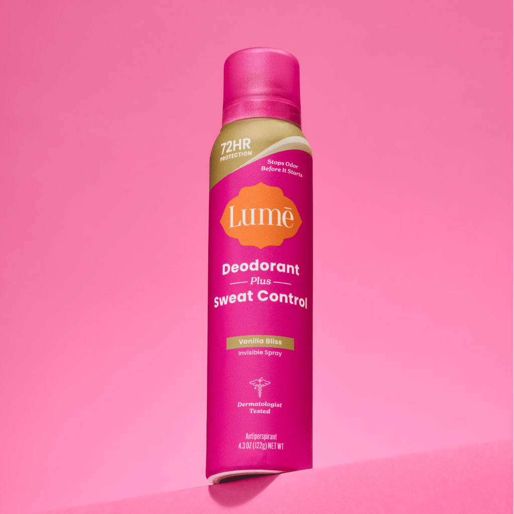 A can of Lume spray deodorant plus sweat control in front a of a pink backdrop.